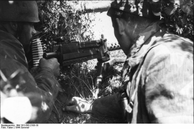 Lato 1944 - Zwei Fallschirmjäger in getarnter Stellung mit erbeutetem, amerikanischen Maschinengewehr Browning M1919, Frankreich.jpg